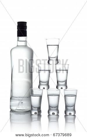 Bottle With Many Glasses Of Vodka Isolated On White Background