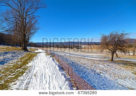 Skiing fields in West Virginia with picturesque background of forest trees and farmhouses.