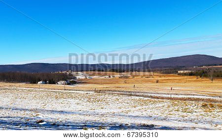 Skiing fields in West Virginia with picturesque background of forest trees and farmhouses.
