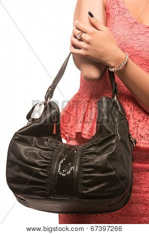 Closeup of woman with black leather bag. Wearing pink mini lace dress. Isolated on the white studio background.