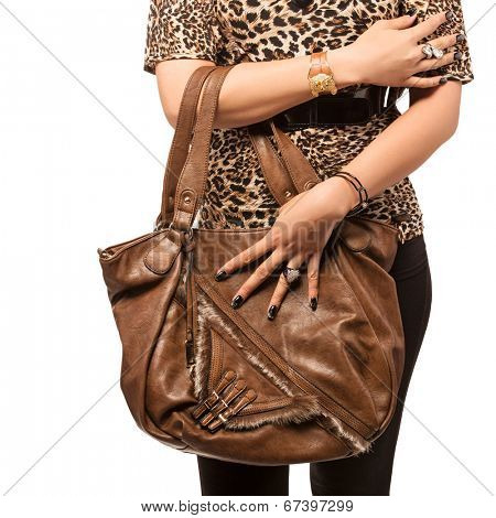 Closeup of woman with brown leather and fur bag wearing black tights and leopard top. Isolated on the white studio background