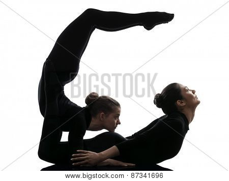 two women contortionist practicing gymnastic yoga in silhouette on white background