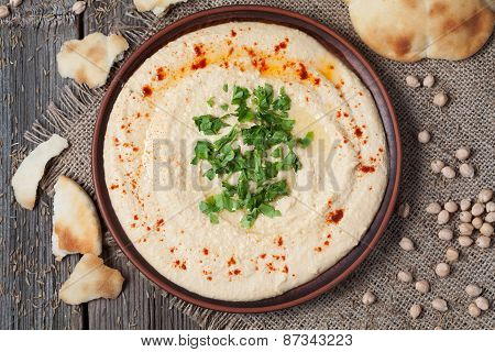 Bowl of hummus, creamy vegetarian food with chick-peas, paprika, olive oil and pita flatbread