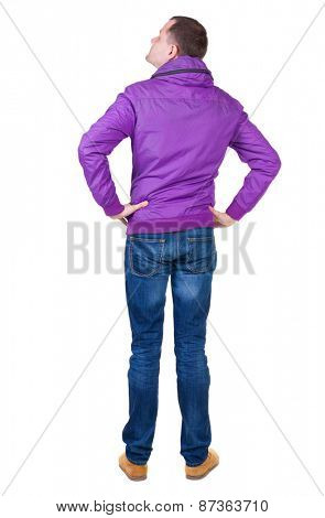 Back view of handsome man in brown windcheater looking up.   Standing young guy in jeans. Rear view people collection.  backside view of person.  Isolated over white background.