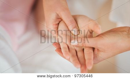 Young woman getting hand massage in therapy room