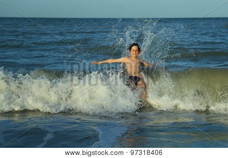 Child Plunges Over The Waves Of The Choppy Sea In Summer