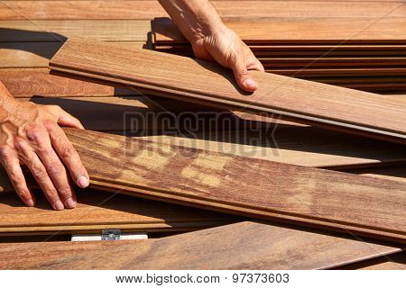 Ipe decking installation with carpenter hands holding tropical wood slats
