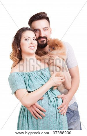Pregnant Woamn With Dog In Hands And Husband Beside Her