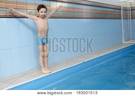 Сhild is preparing to jump into the swimming pool