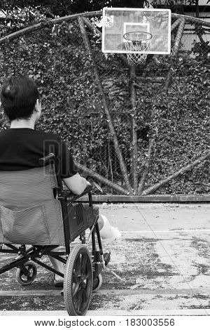 Man Standing With Broken Leg In Plaster Cast Using Crutches At Basketball Court