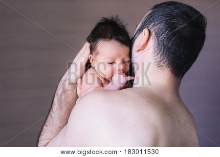 Newborn baby and dad. Baby boy crying on his father shoulder.