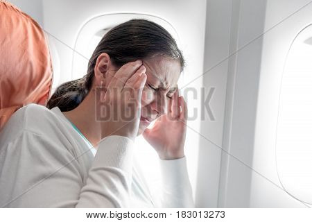 Portrait of a woman with a headache on an airplane