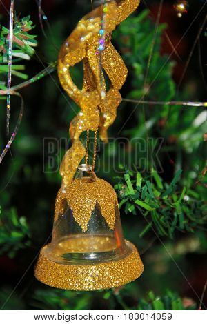 Gold sparkling Christmas bell on the tree