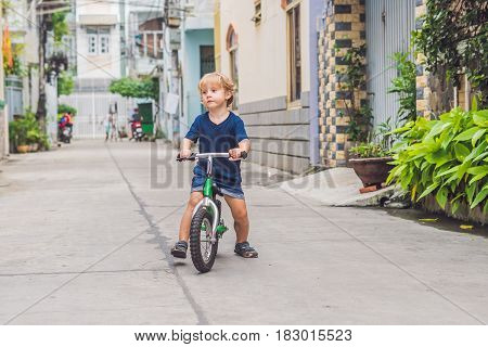 Active Blond Kid Boy Driving Bicycle N The Street Of The City. Toddler Child Dreaming And Having Fun