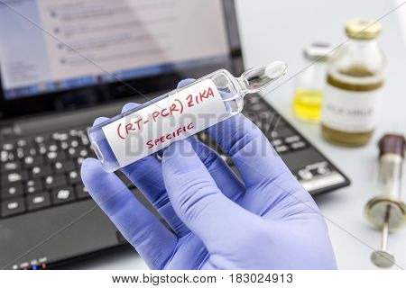 Scientist With Blue Latex Gloves Holds Vials Of Zika Virus In Laboratory For Analysis