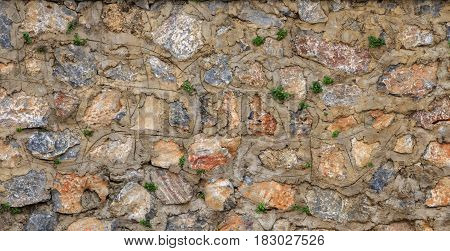 STONES WALL TEXTURE OF AN OLD WALL WITH PLANTS