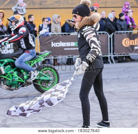 St. Petersburg Russia - 15 April, Girl with checkered finish flag,15 April, 2017.
International Motor Show IMIS-2017 in Expoforurum.
Sports motorcycle show of bikers on the open area.