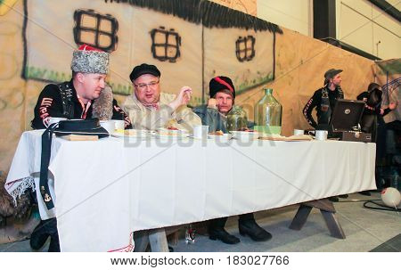 St. Petersburg Russia - 15 April, People at the table with moonshine and snack,15 April, 2017.
International Motor Show IMIS-2017 in Expoforurum.
Visitors and participants of the annual moto-salon in St. Petersburg.