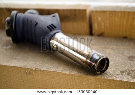 Blow torch without gas baloon on wood background.