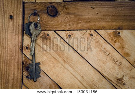 Old rusty keys on the wooden wall background.