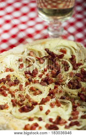 flammkuchen closeup with a glass of wine