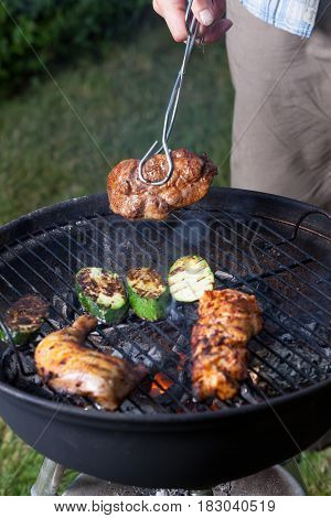 closeu of grill cooking out in the backyard