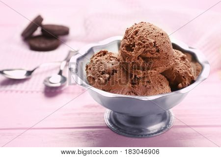 Metal bowl with delicious chocolate ice cream on pink wooden table