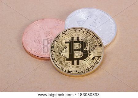 gold silver and bronze coins bitcoin on the background of bright paper