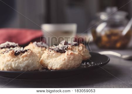 Plate with delicious coconut macaroons on table
