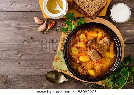 Shchi - traditional russian cabbage soup on wooden table. Rustic style. Top view.