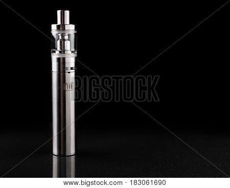 metallic electronic cigarette or vaping device on black background