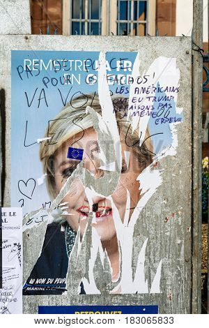 STRASBOURG FRANCE - APR 23 2017: Official campaign posters of Marine Le Pen political party leader of Front national (FN) vandalized on the first round of 2017 French presidential election