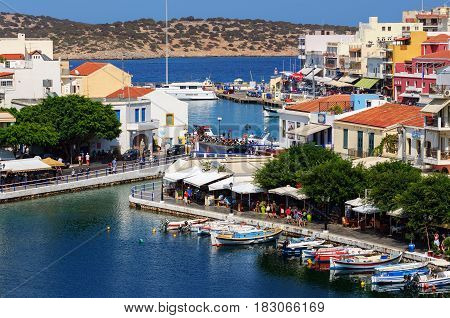 AGHIOS NIKOLAOS, CRETE, GREECE - AUGUST 2016: Small harbor with moored fishing boats at Aghios Nikolaos town on Crete island, Greece