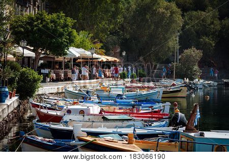 AGHIOS NIKOLAOS, CRETE, GREECE - AUGUST 2016: Small harbor with moored fishing boats at Aghios Nikolaos town on Crete island, Greece