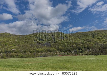 Meadows and hills near Kostov village in green valley of Bilina river