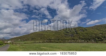 Meadows and hills near Kostov village in green valley of Bilina river