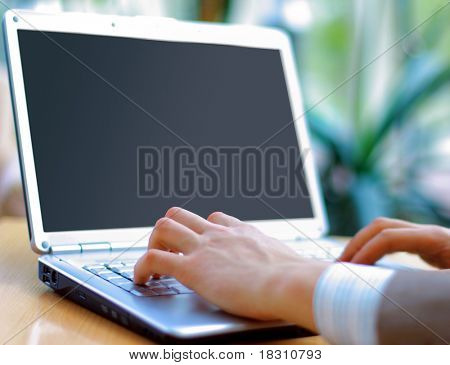 Person at skrive på en moderne bærbar computer i et kontor
