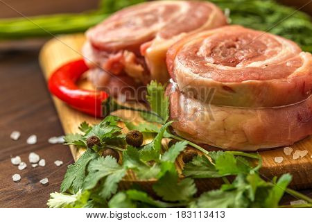 raw breast wrapped in a roll with ingredients for cooking meat.