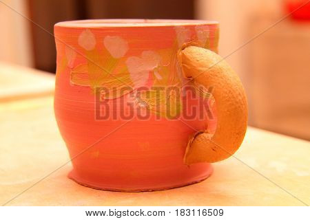 earthenware mug with handle colorized, pottery craft, moulding the pot with your hands, sculpting hands