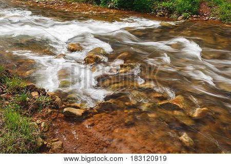 Fast moving river water in spring, long exposure, close up
