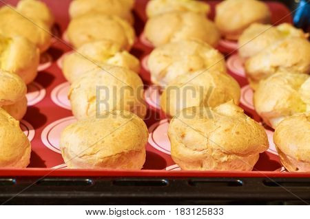 Close up of cooked homemade profiteroles on a tray