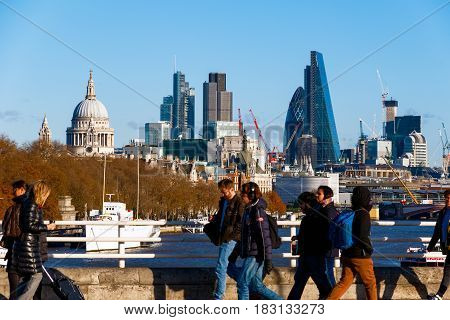 London UK - March 13 2017 - City of London seen from Waterloo Bridge with blurred pedestrians in the foreground