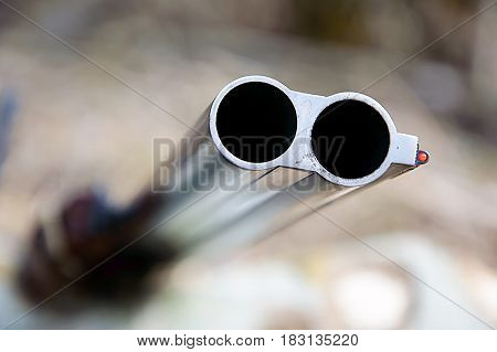 Muzzle of double barreled shotguns pointed - macro shooting. Hunting rifle takes aim at the victim. Eyes on the target.