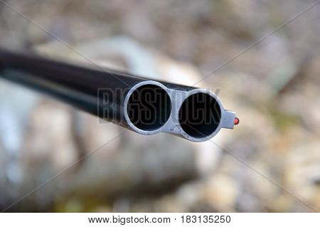Muzzle of double barreled shotguns. Shotgun pointed at me - macro shooting. Hunting rifle takes aim at the victim. Eyes on the target.