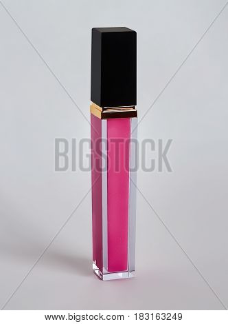 Pink lip gloss isolated on a gray