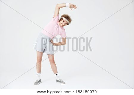 Retro sport 70. Full length portrait of man stretching back muscles leaning to left