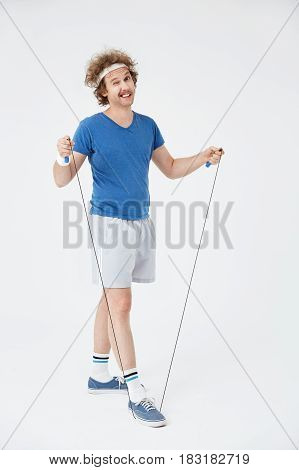 Man exercising with jumping rope isolated on white background winking at camera with right eye