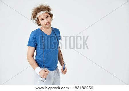 Closeup of retro tired athlete with skipping rope on shoulders, looking straight at camera