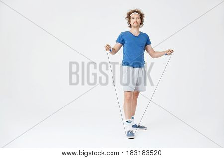 Man in retro sport outfit holding jumping rope in hand, about to start training