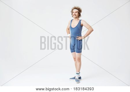 Retro man in old fashioned blue sport suit looking straight, posing with arms akimbo